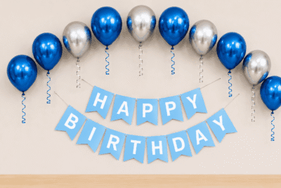 Blue Silver Metallic Birthday Decoration Blue and silver metallic birthday decoration with balloons, ribbon curls and happy birthday banner for party setup.
