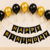 Black and gold happy birthday decoration with metallic balloons, curling ribbons and elegant birthday banner for party setup.