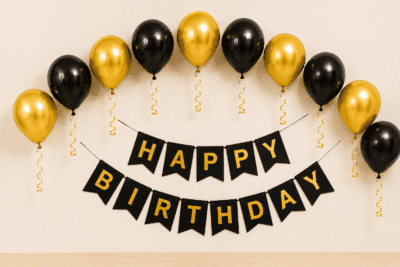 Black and Gold Birthday Balloon Decoration Black and gold happy birthday decoration with metallic balloons, curling ribbons and elegant birthday banner for party setup.