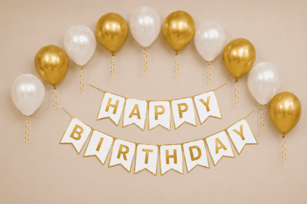 Gold and White Birthday Balloon Decoration Gold and white happy birthday decoration with metallic balloons, ribbon curls and elegant birthday banner for party setup.