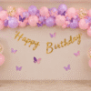 Butterfly Theme Birthday Decoration Butterfly theme birthday decoration with pink, purple, peach and white balloons, butterfly stickers and gold Happy Birthday banner.