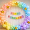Pastel Rainbow Birthday Balloon Decoration Pastel rainbow birthday decoration with balloon arch, gold star foil balloons, fairy light curtain and happy birthday banner.