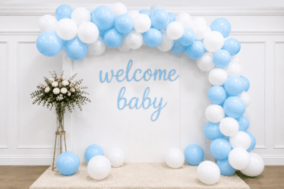 Blue and white welcome baby balloon decoration with balloon arch, cursive welcome baby banner and flower stand for baby shower or newborn welcome party.